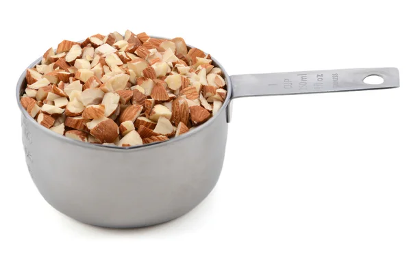 Chopped almonds in a metal cup measure — Stock Photo, Image