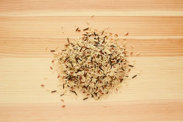 Wild rice, brown basmati and red camargue grains on wood — Stock Photo, Image