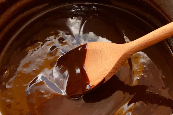 Chocolate derretido sendo mexido com uma colher de madeira — Fotografia de Stock
