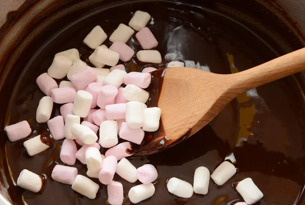 Mexendo mini marshmallows em chocolate derretido — Fotografia de Stock