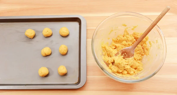 Añadir bolas de masa de galletas a una bandeja para hornear — Foto de Stock