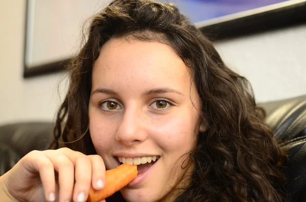 Beautiful young teenage girl eating carrot — Stock Photo, Image