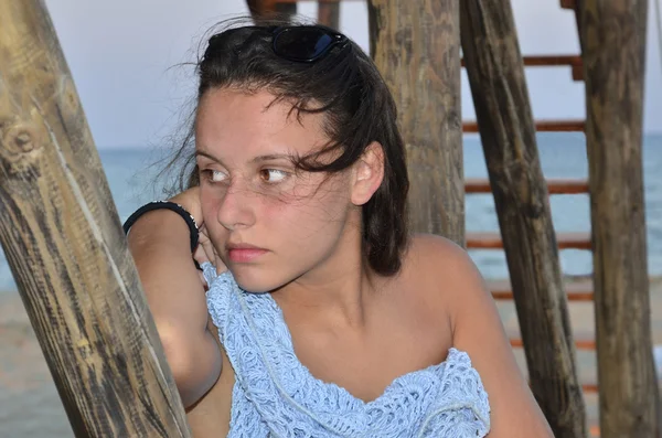 Porträtt av ung vacker flicka med Bosse titta på havet trähus inlägg — Stockfoto