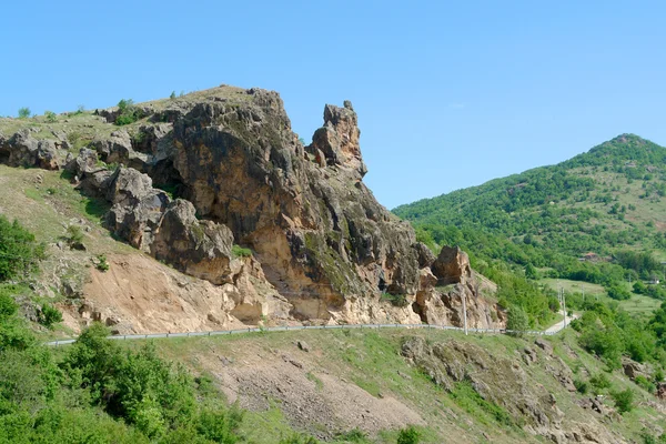 Paisaje con rocas colina y cielo azul claro sobre la carretera —  Fotos de Stock