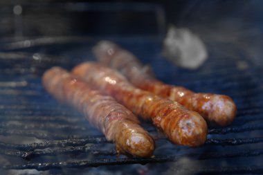 Fresh sausage and hot dogs grilling clipart