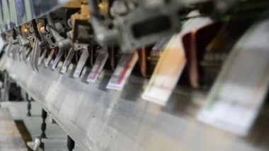 dergi, broşür işlemini dikiş ofset. yakın çekim tam otomatik dikiş birim taşıma sürecinin.