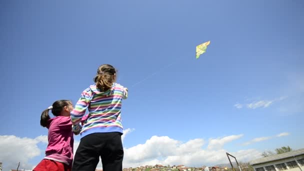 Маленькие девочки запускают воздушного змея под широким углом. — стоковое видео