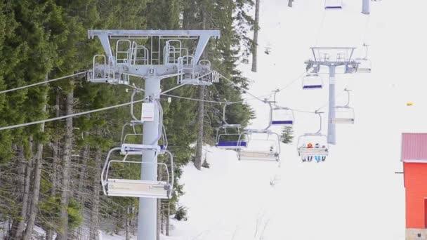 Ski resort, chair ski lift elevator lifting on the mountain ski slope — Stock Video