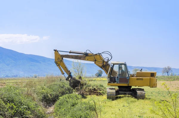 Bagger steht mit Hubschaufel über Wolkenhimmel — Stockfoto