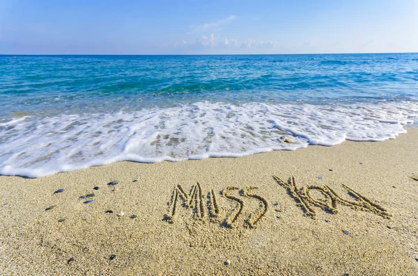 Word MISS du trukket på sandet på en strand - Stock-foto