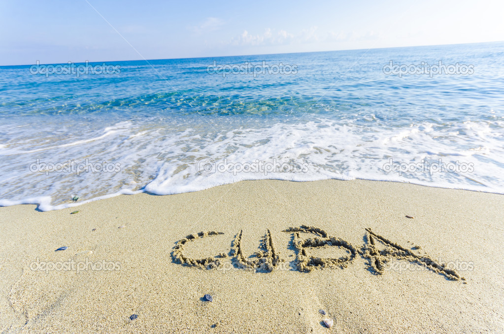 Word CUBA drawn on the sand of a beach