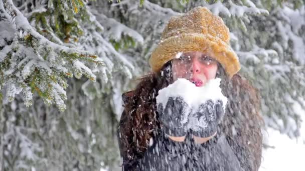 Подросток раздувает снежки перед камерой — стоковое видео