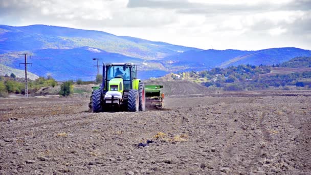 Трактор за работой на сельскохозяйственных землях — стоковое видео