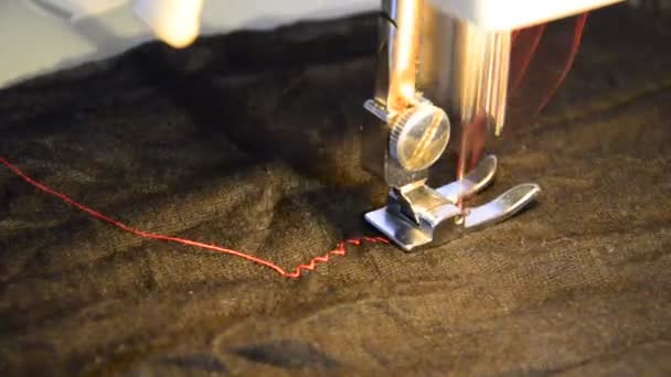 Machine à coudre et vêtement noir avec fil rouge contrasté 