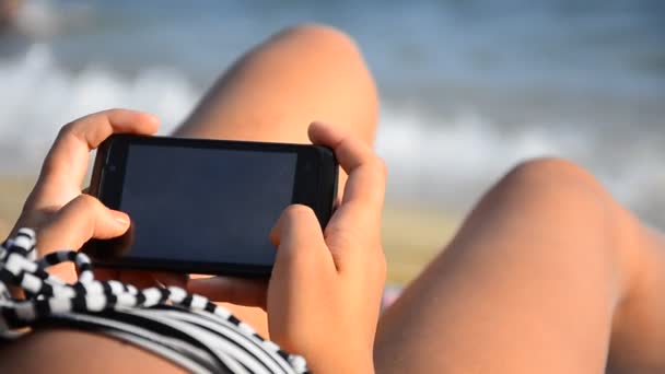 Žena pomocí smartphone na pláži — Stock video