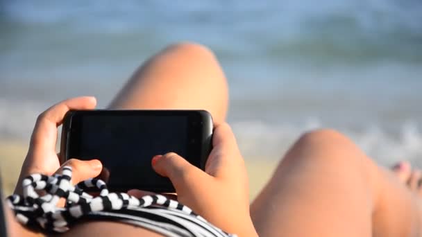 Mujer usando smartphone en la playa — Vídeos de Stock