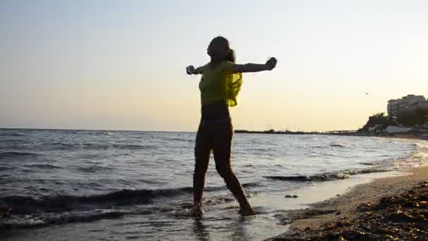 Girl turns spiritual on a beach sand at sunset — Stock Video