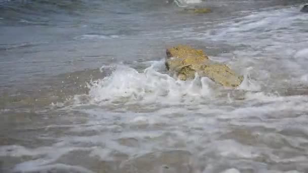 Éclaboussures d'eau sur la roche de plage 
