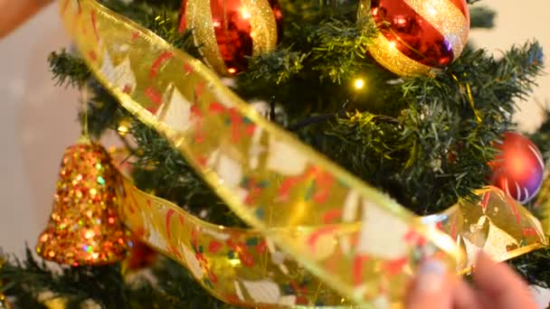 Poner adorno de cinta en el árbol de Navidad — Vídeo de stock