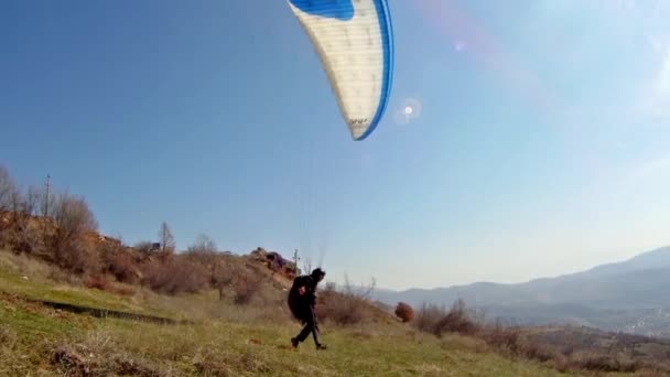Paraglider taking off van een bergketen — Stockvideo