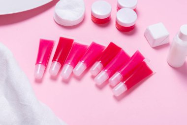 Pembe arka planda ev yapımı dudak parlatıcıları var.