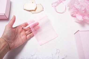 Tahta masada bir sürü pembe organza hediye kutusu var.