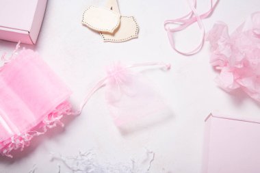 Tahta masada bir sürü pembe organza hediye kutusu var.