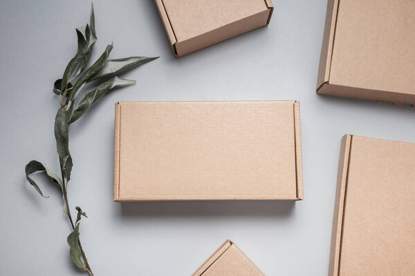 Бурый плоский картонная коробка украшена сушеными листьями, сверху