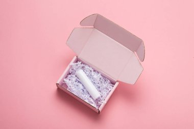 Beyaz ruj pembe arka planda karton paket kutusunda