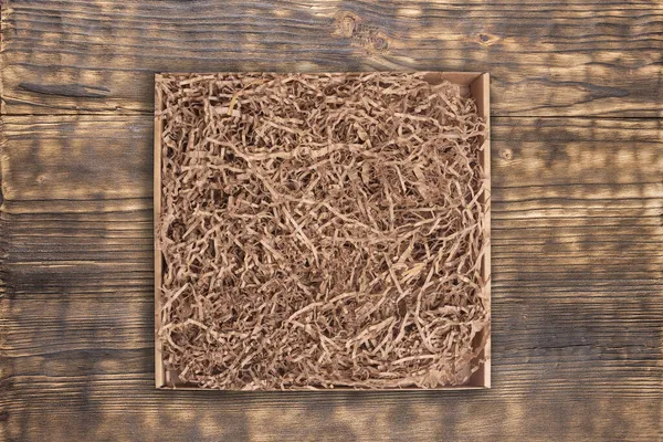 Karton Mit Papierfüller Auf Holzgrund — Stockfoto