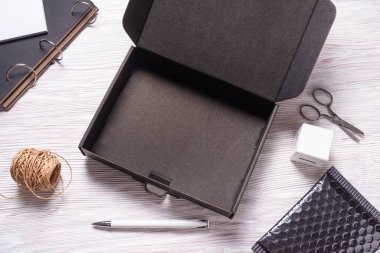 Ahşap ofis masasındaki siyah karton kutu.