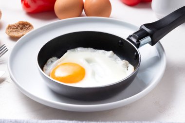 Çırpılmış, porselen üzerinde küçük bir tavada bir yumurtadan kızarmış yumurta.