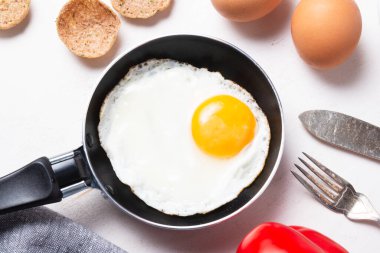 Çırpılmış, porselen üzerinde küçük bir tavada bir yumurtadan kızarmış yumurta.