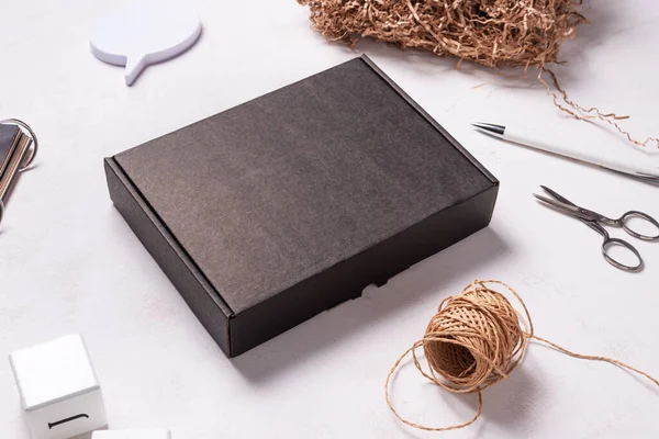 Ahşap ofis masasındaki siyah karton kutu.