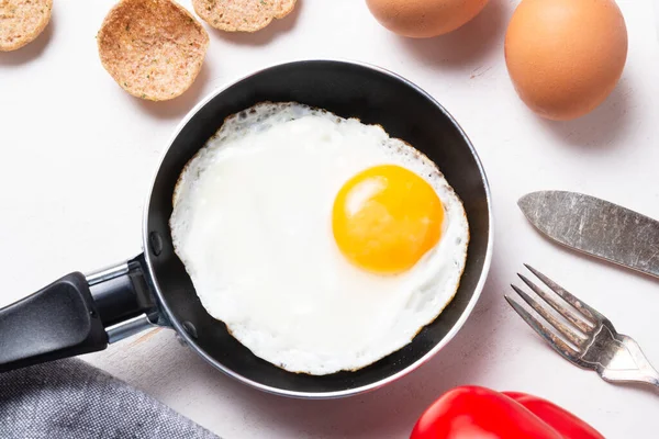 Çırpılmış, porselen üzerinde küçük bir tavada bir yumurtadan kızarmış yumurta.