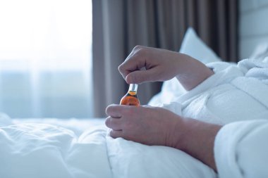 Kötü durumda olan adam elinde küçük bir şişe Wiskey, alkolik.