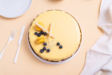 Bej arka planda tutkulu meyveli kremalı pasta