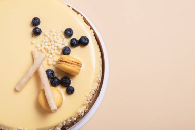 Bej arka planda tutkulu meyveli kremalı pasta