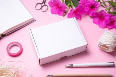 White cardboard, carton box on pink background decorated with re