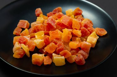 Siyah arka planda şekerli meyve ananası ve papaya 