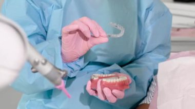 Diş hizalaması için görünmez diş teli tutan ortodontiste yakın çekim. Klinikte hasta modern diş teknolojisi - çıkarılabilir şeffaf plastik hizalayıcılar veya geçersiz kullanım ve fayda. 
