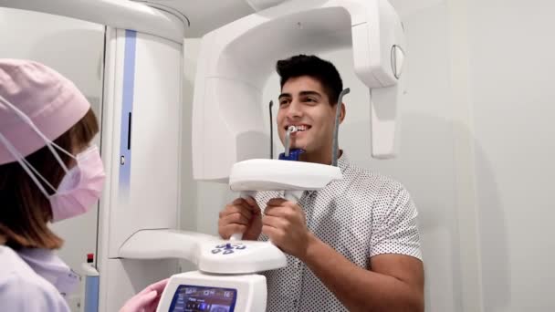 Νεαρός ασθενής στέκεται στο μηχάνημα ακτίνων Χ. Πανοραμική ακτινογραφία. — Αρχείο Βίντεο