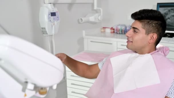 Paziente felice che si fa un selfie alla clinica dentistica. Il paziente tiene lo smartphone e mostra il suo sorriso sano. — Video Stock