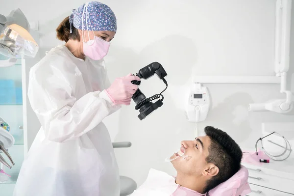 아름다운 젊은 환자들이 웃는 모습을 카메라로 찍는 치과 의사. — 스톡 사진