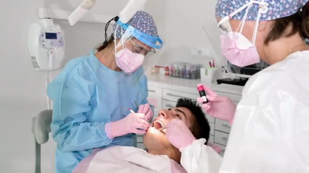 Dentystka leczy ubytek zęba. Pacjent z próchnicą na krześle. Koncepcja opieki stomatologicznej. — Wideo stockowe