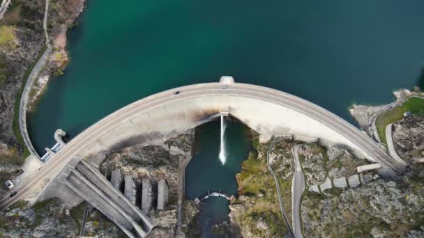 空景无人驾驶飞机在水坝上方鸣枪 在水力发电厂上方的一个有沥青公路桥梁的水塘上 顶部朝下拍摄 高质量的4K镜头 — 图库视频影像
