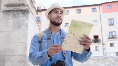 Turistin elinde haritayla sokakta yürüyüp eski anıtlara bakarken çekilen fotoğrafı. Yüksek kalite 4k görüntü