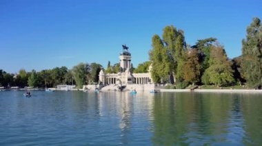 İspanya 'nın başkenti Madrid' de Buen Retiro Park Gölü 'nde teknelerden keyif alan turistler.