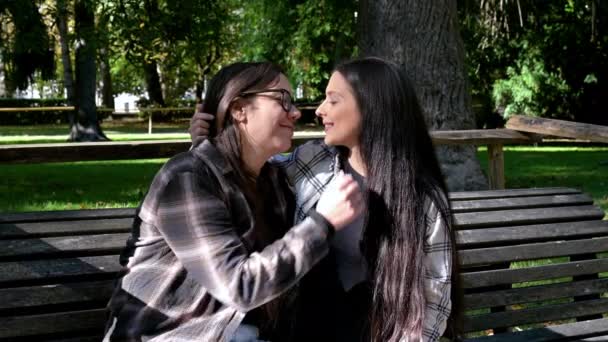 Felice amare giovane coppia lesbica baciare e rilassarsi insieme su una panchina del parco. — Video Stock