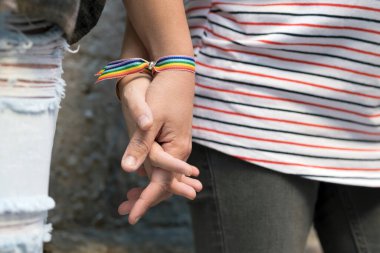 Gökkuşağı bilekliği takan mutlu lezbiyen çift, LGBT aşk konsepti..
